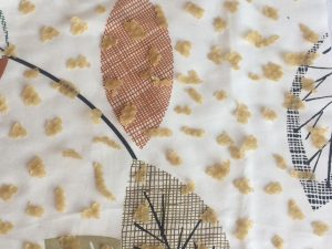 Równomierne rozłożenie grudek wosku pszczelego na wyciętym materiale bawełnianym